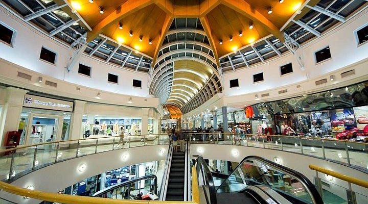 Galería comercial con techo curvo y mensaje sobre eventos y actividades mensuales.